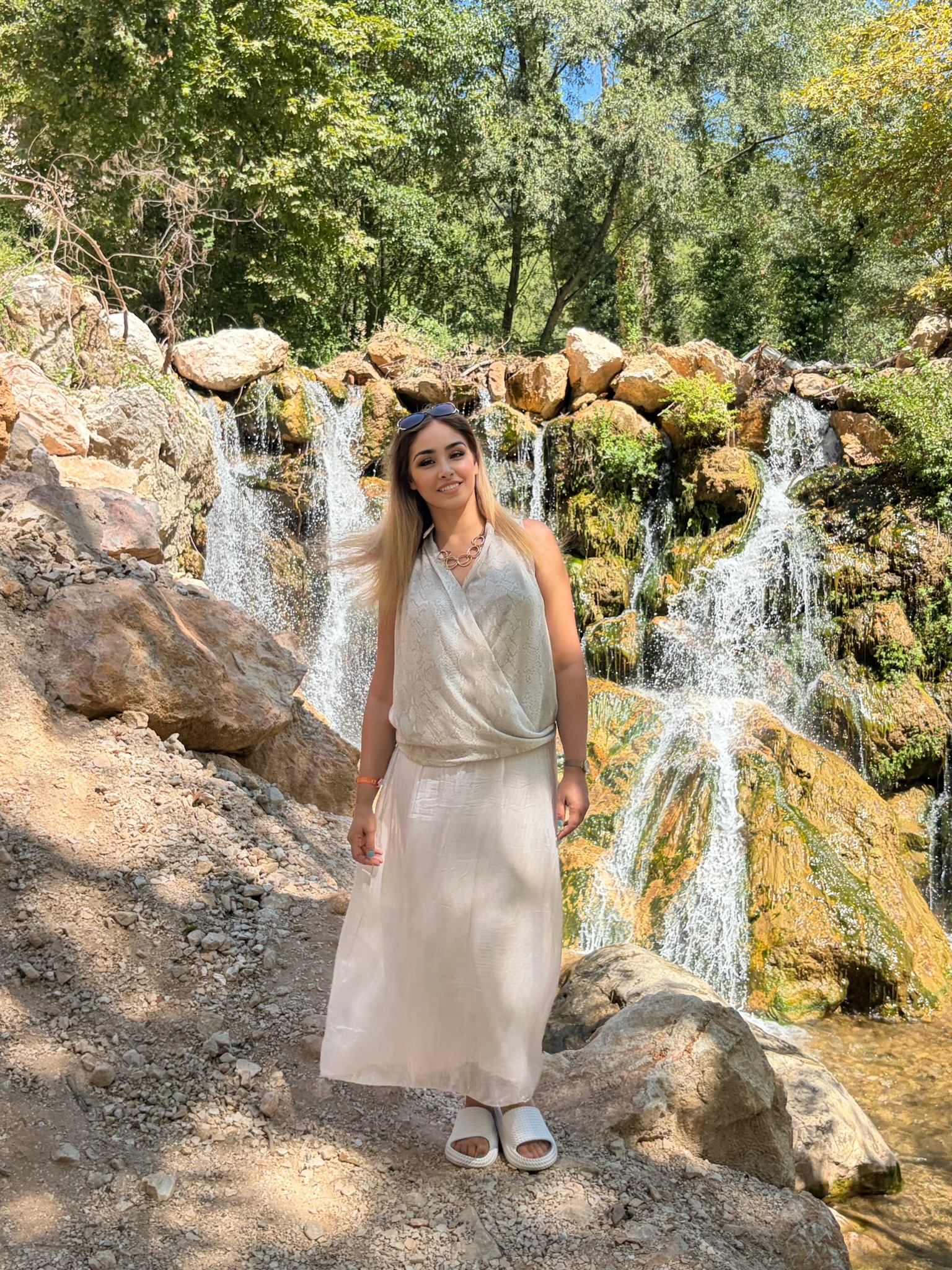 Sara vor einem Wasserfall auf Reisen