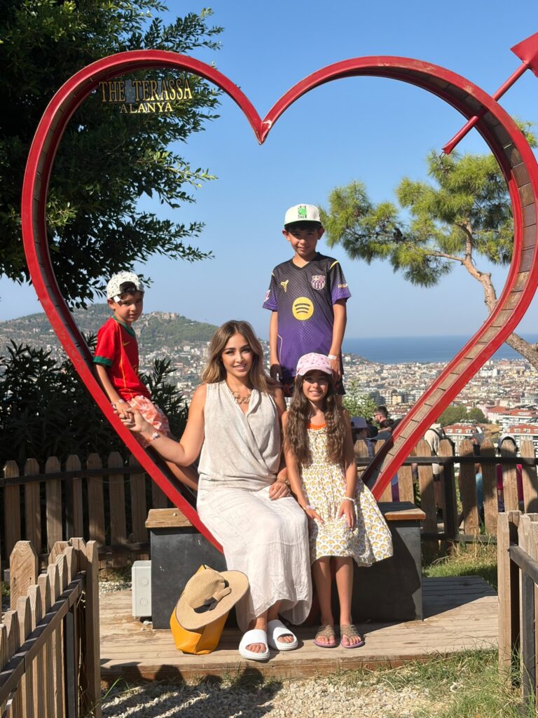 Sara mit ihren drei Kindern im Herzrahmen über Alanya
